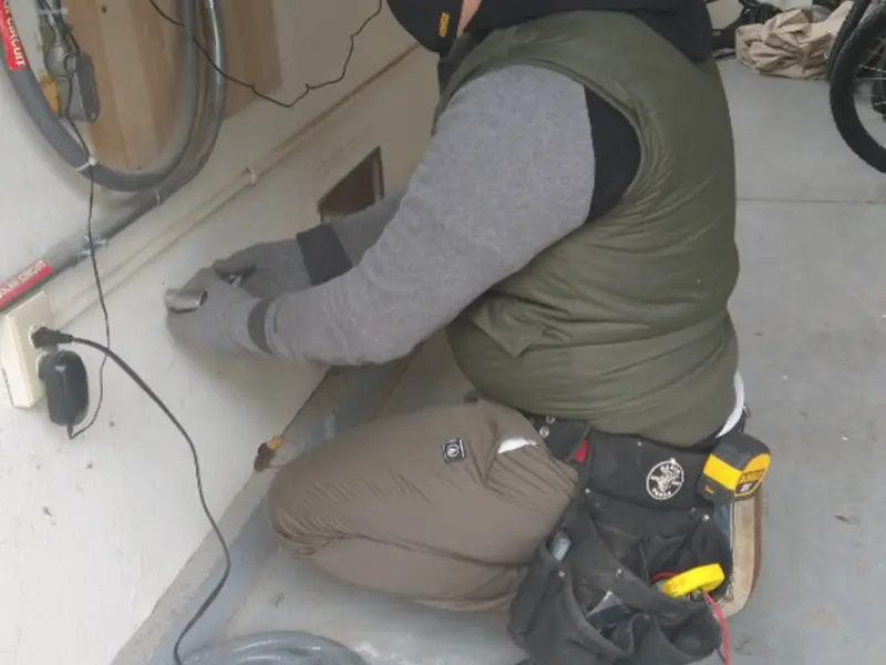 Electrician performing outlet wiring in a Satsuma garage